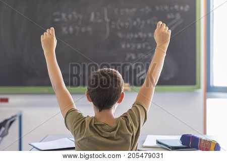 Student With Hands Up In Classroom During A Lesson