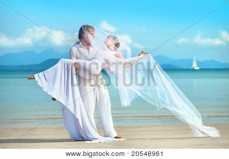 красивая пара на пляже в свадебное платье