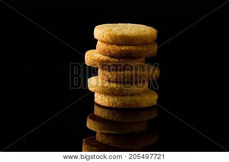 a tower made of shortbread cookies on a black glossy background