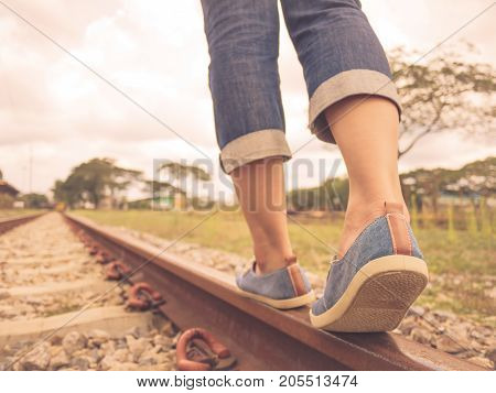 Retro style of woman walking on the railway. Travel and step concept.