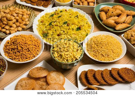 stock photo of  Diwali food or Diwali snacks or Diwali sweets like anarsa, bakarvadi, chakli, sev, bhujiya, shankar pale and chivda or chiwada, karanji, favourite indian diwali recipe, selective focus