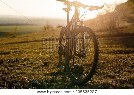 Silhouette of Mountain bike on the meadow at sunset. Travel concept