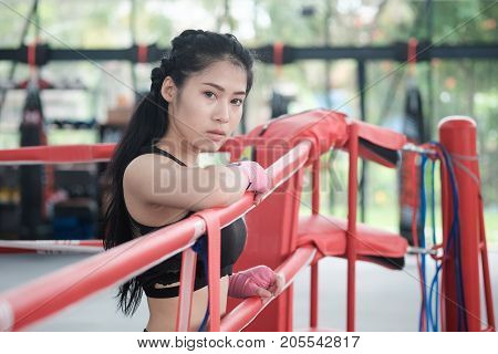 Portrait asian woman on ringside boxing gym.