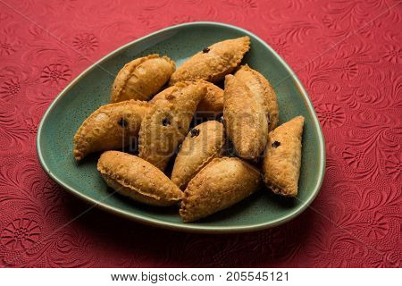 Stock Photo of Karnaji or gujia is a sweet dumpling made from maida and stuffed with khoya . It is common sweet in north India and these are usually on diwali or festival time, selective focus