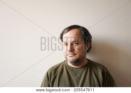 authentic real man in his forties against interior wall with copy space and natural lighting