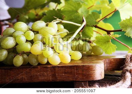Grapes on wooden table and grape leaves . Healthy fresh fruit wine grapes.