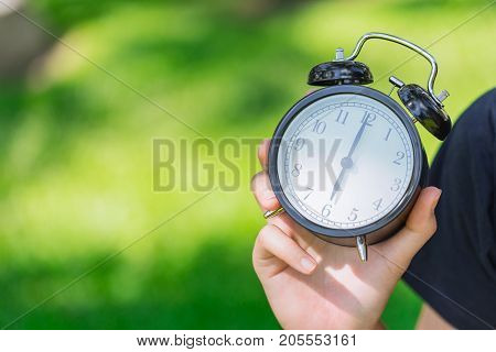 Clock On Hand Show Time At 6 O'clock On Green Park Background