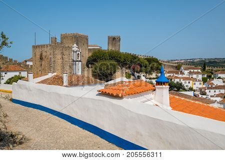 Narrow street and Castle of Obidos. Portugal