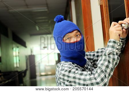 Masked burglar escaping after sneaking into the house. Crime crysis concept