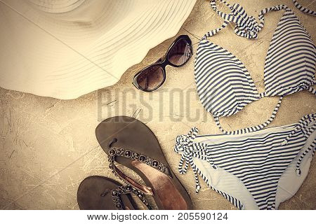 Female summer striped bikini swimsuit, clothes and accessories collection on gray background. Flat lay, top view