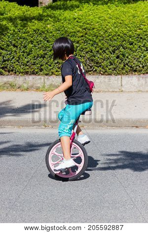 OSAKA JAPAN - SEPTEMBER 18 : unidentified asian little girl riding a unicycle (one wheel bike) in a park on September 18 2017 in Osaka Japan.