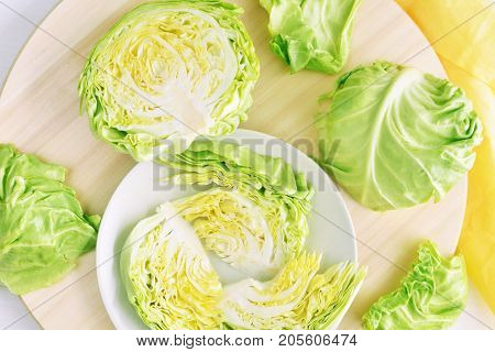 fresh green cut head of cabbage on ceramic gray plate, wooden and material background