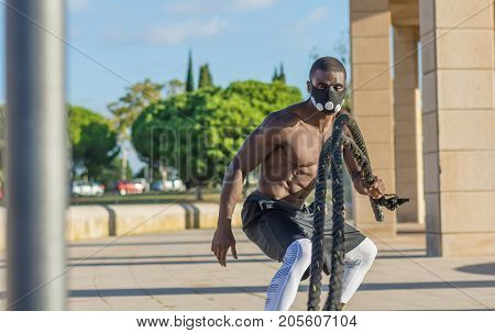 Male Muscular Training With Battle Ropes And Training Mask