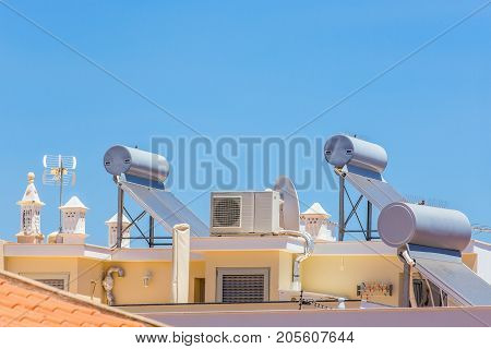 Solar collectors and boilers with airco on roof of house