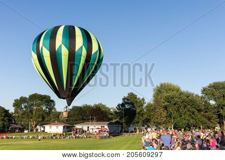 Seymour WI - August 12 2017: Hot air balloon rising above the crowd during Hamburger Fest in Seymour WI. Hot air balloons are an integral part of the annual festival which celebrates Seymour as the birthplace of the hamburger.