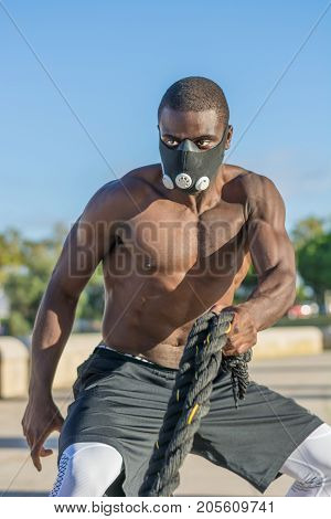 Male Muscular Training With Battle Ropes And Training Mask