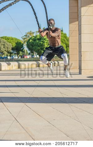 Male Muscular Training With Battle Ropes And Training Mask