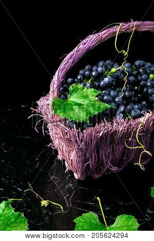 Red Wine Grapes In Voiolet Basket On Bllack Background.
