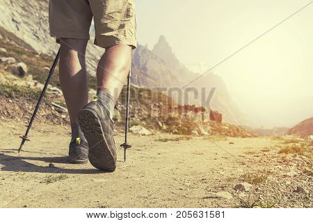Hiker with backpacks reaches the summit of mountain peak. Success freedom and happiness achievement in mountains. Active sport concept.
