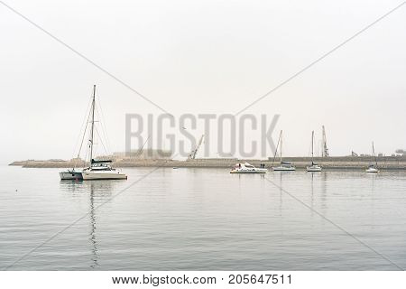 WALVIS BAY NAMIBIA - JULY 1 2017: Yachts with the new harbor container terminal under construction in Walvis Bay on the Atlantic Coast of Namibia