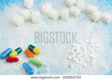 Heap of white sugar with colourful capsules