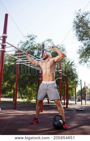 Full length of sporty and healthy muscular man exercising outdoors. Sexy young man with a muscular body on a natural background. Strong and perfect male body.