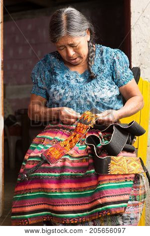January 20 2015 San Pedro la Laguna Guatemala: indigenous tzutujil mayan woman working on a traditional belt