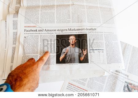 PARIS FRANCE - SEP 25 2017: Man reading international newspaper about Mark Zuckerberg Facebook CEO intention to sell 18% of social network stocks