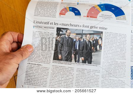 PARIS FRANCE - SEP 25 2017: Man reading international newspaper about Emmanuel Macron French President and Edouard Philippe French Prime-Minister