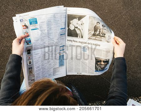 PARIS FRANCE - SEP 25 2017: Woman reading international newspaper about Irving Penn exibition at Grand Palais in Paris France