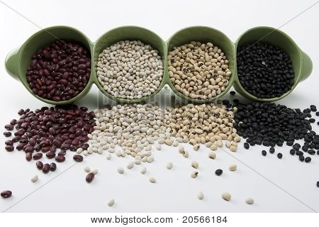Surtidos frijoles mixtos se derrame de un plato de cerámico verde