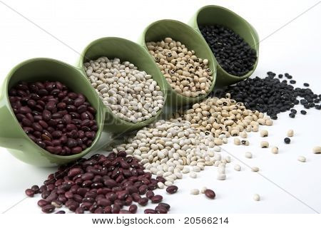 Surtidos frijoles mixtos se derrame de un plato de cerámico verde