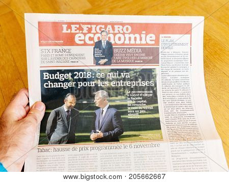 PARIS FRANCE - SEP 25 2017: Man reading international newspaper about French economy with Edouard Philippe and Bruno Le Maire Budget 2018