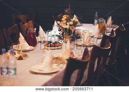 Elegant Restaurant Table with flowers and dishes in studio