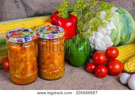 jars with winter supplies, banks with salad are on the table with vegetables