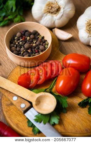 A mixture of colored peppers in a wooden dish, with chili tomatoes