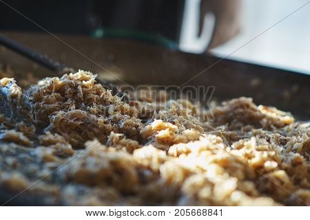Freshly prepared juicy traditional Bavarian cabbage in a large frying pan during the octoberfest season. Soft focus and backlight.
