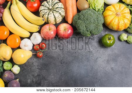 Above view of different rainbow vegetables and fruits on the light grey background, copy space for text below, selective focus