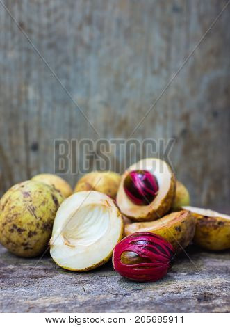 Nutmeg With Placenta-like Cover Of Seed Of Myristica Fragrant On Wooden Background.