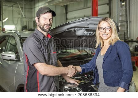 An auto mechanic and female customer in garage