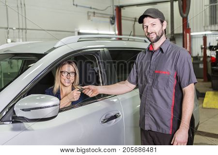 An auto mechanic and female customer in garage