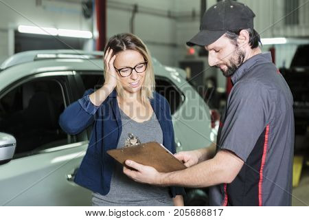 An auto mechanic and female customer in garage
