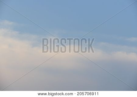 Cloudy sky in the evening light of the beautiful orange sunset.
