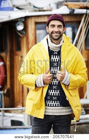 Cute Handsome fisherman in waterproof jacket portrait