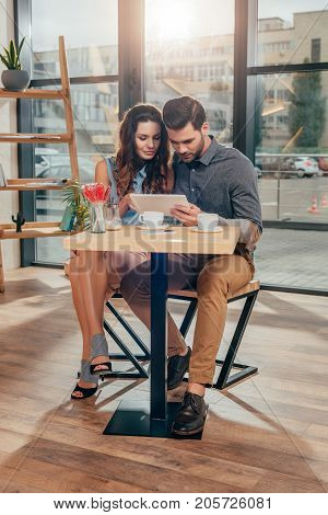 Couple Using Tablet In Cafe
