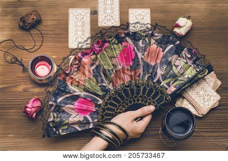 Fortune teller female hand and tarot cards on wooden table. Fortune teller divination.