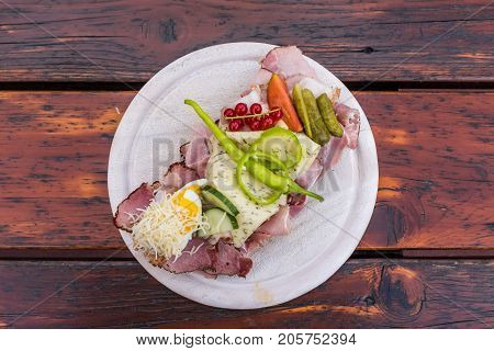 Traditional bread with lots of cold cuts on wooden table on south Styrian vine route in Austria
