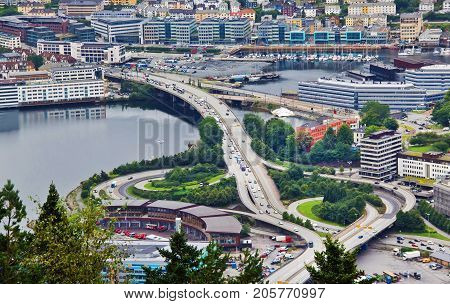 Aeriel view of a freeway interchange Bergen Norway. Urban landscape with bridge roads trafic houses cars and some pond. Modern european city highway