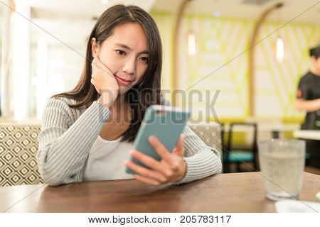 Woman using smart phone in restauarnt 