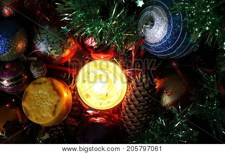 Burning Candle And Christmas Decorations In The Box.